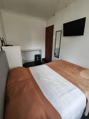 a bedroom with a large bed and a flat screen tv at Habitación acogedora cerca a Larcomar in Lima