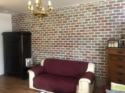 a living room with a couch and a brick wall at Sunny refuge with large gardens in Cieneguilla