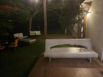 a white couch sitting on a patio at night at Sunny refuge with large gardens in Cieneguilla