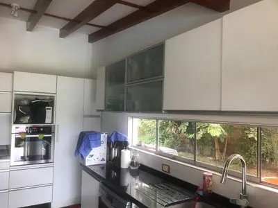 a kitchen with white cabinets and a counter top at Sunny refuge with large gardens in Cieneguilla