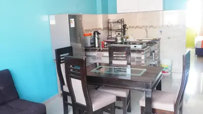 a kitchen with a wooden table with chairs and a stove at BR Comfortable Stay Inn in Cusco