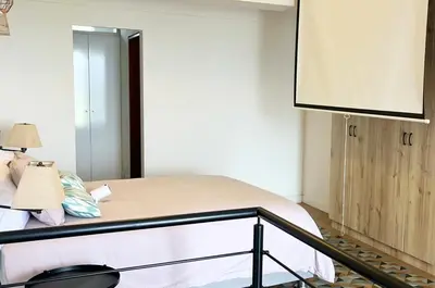 a bedroom with a bed and a large mirror at Duplex con piscina en Miraflores in Lima