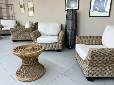 a living room with wicker chairs and a vase at Duplex con piscina en Miraflores in Lima