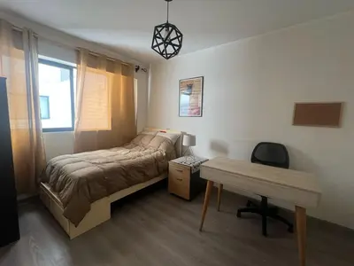 a bedroom with a bed and a desk and a table at Stay, explore and enjoy Lima in Lima