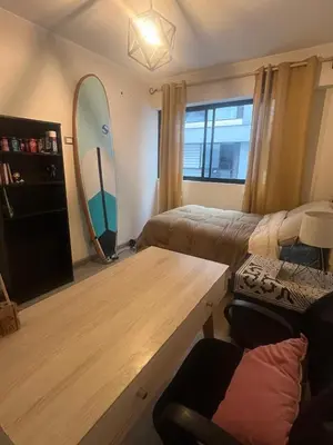 a living room with a table and a surfboard on the wall at Stay, explore and enjoy Lima in Lima