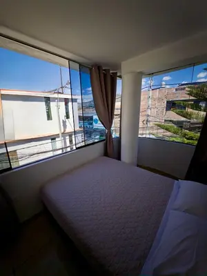 a bedroom with a bed and two large windows at DEPARTAMENTO en el centro!! in Ayacucho