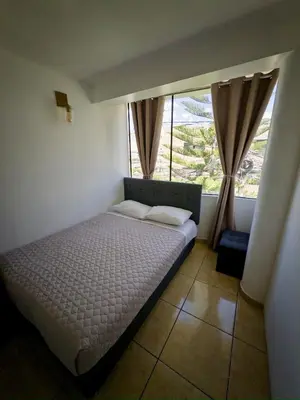 a bed in a room with a large window at DEPARTAMENTO en el centro!! in Ayacucho