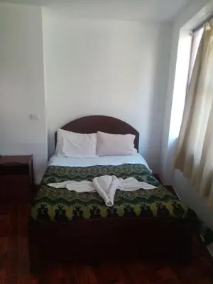 a bedroom with a bed with two towels on it at Hostal Aylluq Wasin - Guest House-Casa de Familia in Urubamba