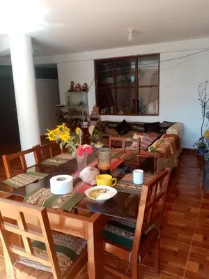 a living room with a table and chairs at Hostal Aylluq Wasin - Guest House-Casa de Familia in Urubamba