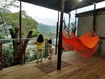 two girls standing on a balcony with a hammock at Casa Hospedaje Terraza con vista a La Merced in La Merced