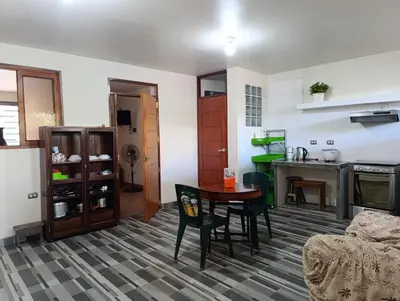 a living room with a table and a kitchen at Casa Hospedaje Terraza con vista a La Merced in La Merced