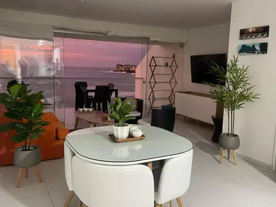 a living room with a table and plants in it at Beautiful Apartment 1st ROW - Unsurpassed View in San Bartolo