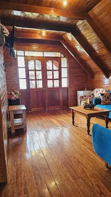 a large living room with wooden floors and a table at La Cabaña de Mary in Oxapampa