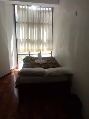 a bed sitting in a room with a window at Hostal Aylluq Wasin - Guest House-Casa de Familia in Urubamba