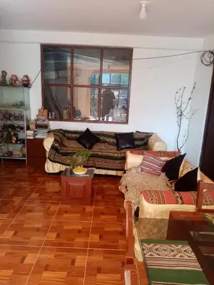 a living room with a couch and a window at Hostal Aylluq Wasin - Guest House-Casa de Familia in Urubamba