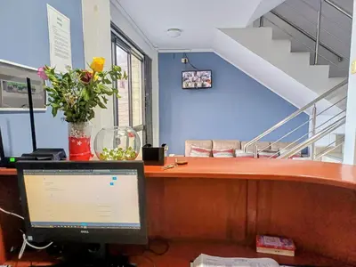 a desk with a computer and a vase of flowers at HsDverdi in Santa María
