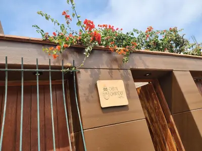 a sign sitting on the side of a building with flowers at China Chancay Hotel in Chancay