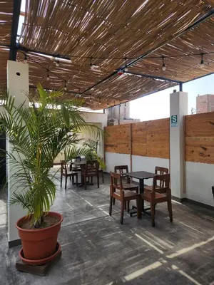 a restaurant with tables and chairs and a potted plant at China Chancay Hotel in Chancay
