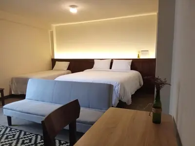 a room with two beds and a couch and a table at China Chancay Hotel in Chancay