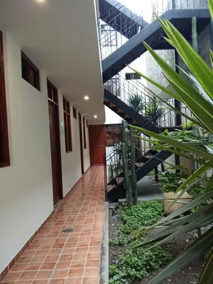 a hallway of a building with stairs and plants at China Chancay Hotel in Chancay