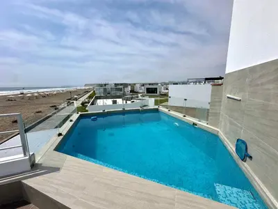 a swimming pool on top of a building next to the beach at Casa de Playa con vista panorámica in Islote Los Leones