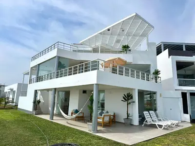 a white house with a lot of windows at Casa de Playa con vista panorámica in Islote Los Leones