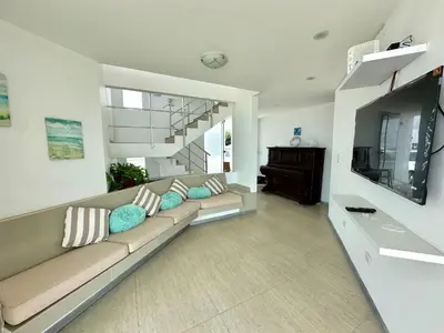 a living room with a couch and a television at Casa de Playa con vista panorámica in Islote Los Leones