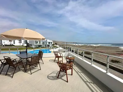 a patio with a table and chairs and the beach at Casa de Playa con vista panorámica in Islote Los Leones