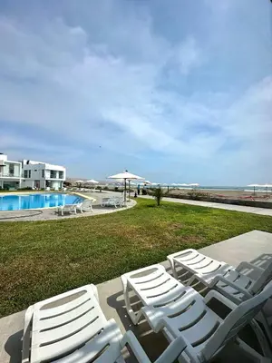a group of white chairs sitting next to a pool at Casa de Playa con vista panorámica in Islote Los Leones