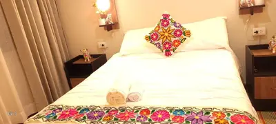 a bedroom with a bed with a pillow on it at Oasis Inka Machupicchu in Machu Picchu