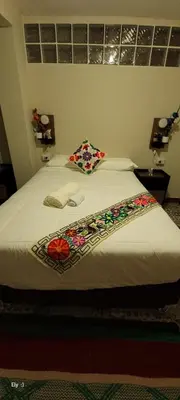 a bedroom with a bed with flowers on it at Oasis Inka Machupicchu in Machu Picchu