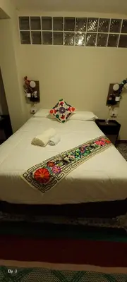 a bedroom with a bed with flowers on it at Oasis Inka Machupicchu in Machu Picchu