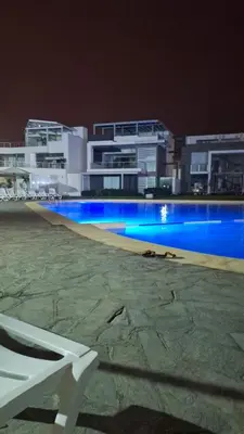 a swimming pool at night with buildings in the background at Asia - Condominio Las Terrazas - departamento lindo y confortable in Islote Los Leones