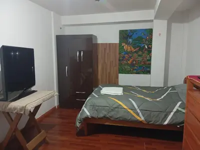a bedroom with a bed with a tv and a painting at Estancia Concepción Cusco - Peru in Cusco