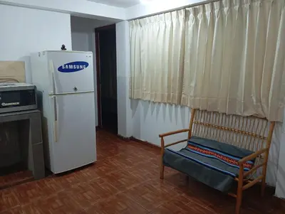 a kitchen with a refrigerator and a chair in a room at Estancia Concepción Cusco - Peru in Cusco