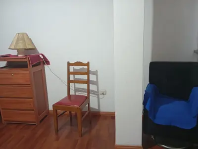 a chair sitting next to a desk with a lamp and a dresser at Estancia Concepción Cusco - Peru in Cusco