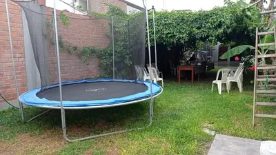 an empty trampoline in a yard with a fence at Casa de campo en Chincha in Chincha
