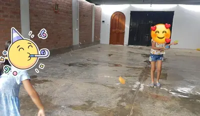 two children standing in a parking lot playing with a ball at Casa de campo en Chincha in Chincha