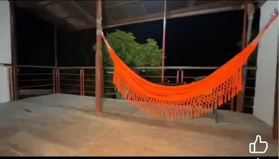 an orange hammock hanging from a building at Casa Hospedaje terraza con vista a La Merced in La Merced
