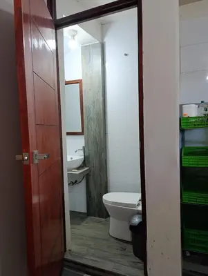 a bathroom with a toilet and a sink and a door at Casa Hospedaje terraza con vista a La Merced in La Merced