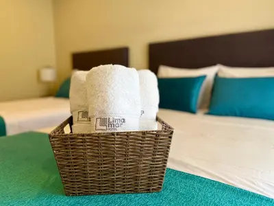 a basket of towels is sitting on a bed at Hotel Limamar in Lima