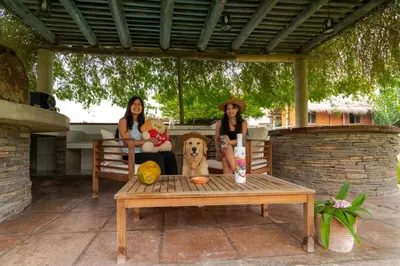 two women and a dog sitting on a bench at Casa linda de Chontay junto al rio in Chontay