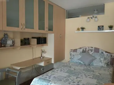 a bedroom with a bed with a desk and a table at Groundfloor, onebedroom apartment in Lima