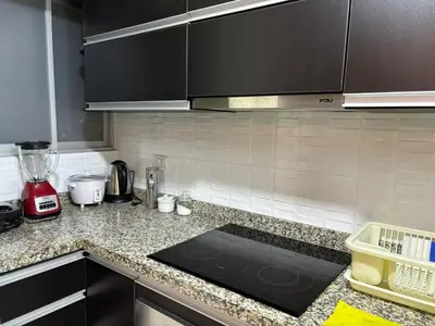 a kitchen with black cabinets and a counter top at Comfort apt in Magdalena front of supermarket! in Lima