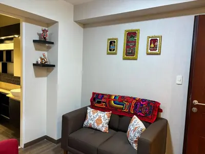 a living room with a couch with a colorful blanket on it at Comfort apt in Magdalena front of supermarket! in Lima
