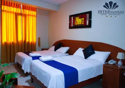 two beds in a hotel room with at Hotel INTERnazionale in Ayacucho