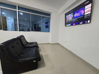 a black leather chair in a room with a tv at 401 Moderno departamento equipado in Abancay