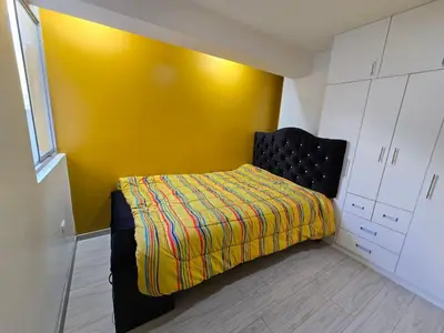 a bedroom with a bed and a yellow wall at 401 Moderno departamento equipado in Abancay