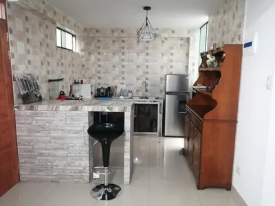 a kitchen with a counter and a refrigerator at Amplio departamento completo cerca al aeropuerto in Lima