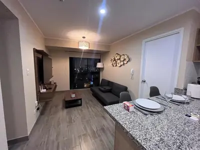 a living room with a couch and a table in a room at The Pool & City Spot - steps from Miraflores in Lima